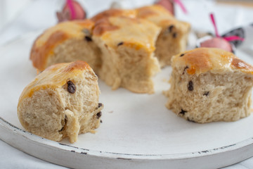 Traditional home made hot cross buns with chocolate chips on a easter table