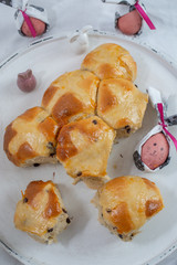 Traditional home made hot cross buns with chocolate chips on a easter table