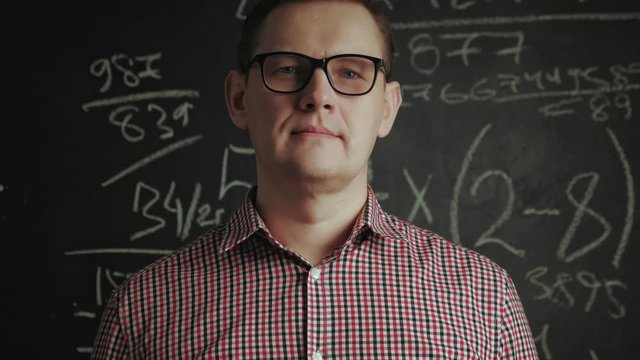 man writes math formula on blackboard