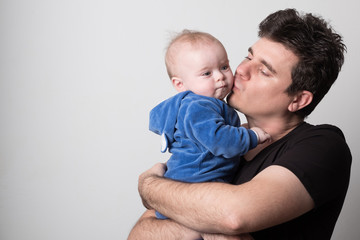 Young dad with a baby. Selective focus. Cute dad is played with a baby.
