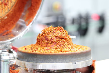 Red ground chili in chili paste grinder machine