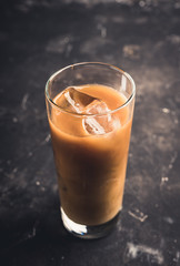 Iced coffee with cream on the rustic background. Selective focus. Shallow depth of field.