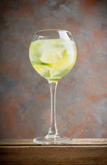 Rum based cocktail with lime in wine glass (variation of cuba libre) on the rustic background. Selective focus. Shallow depth of field.