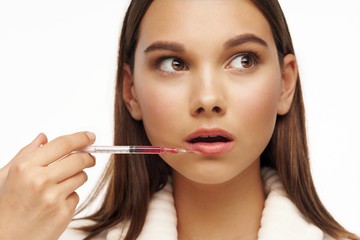 young woman applying lip gloss