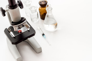 Laboratory examination with microscope. Equipment with blood sample on white background copy space