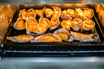 Cooking of Oysters in a creamy sauce and cheese in oven