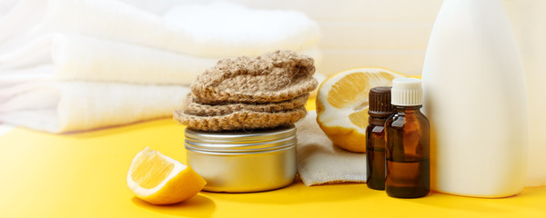 Set of eco-friendly natural cleaning products on yellow kitchen table: soda, essential oils,...