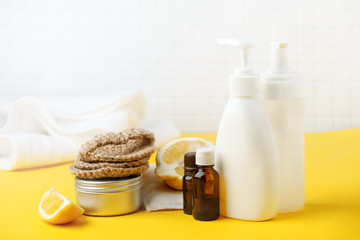 Set of eco-friendly natural cleaning products on yellow kitchen table: soda, essential oils, cellulose sponge, rags, lemon, soap, vinegar. Zero waste, eclogical habbits