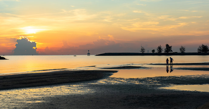 Seascape in morning silhouette 2 kid play water together. Pranburi forest park in Hua Hin district, Thailand.