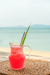 Colorful watermelon mocktail at the beach bar with sea background. Vacation, get away, summer outing concept