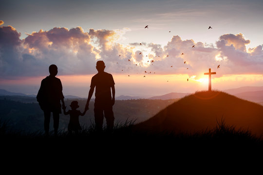 Silhouette family looking for the cross of Jesus Christ on autumn sunrise background