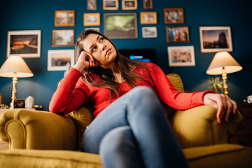 Stressed woman overthinking events alone at home.Thinking of problems/solution.Annoyed and bored at...