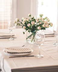 served table with a vase with light roses