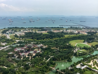 Obraz premium Singapore. Aerial view from the pool of the famous Marina Bay Sand hotel. Gardens by the Bay is a beautiful nature park in the Central Region of Singapore. Supertrees, 18 tree shape structures. 