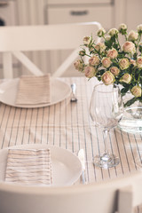 served table with a vase with light roses