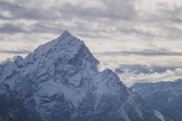 Fototapeta na wymiar Snowy mountain peak around Cortina d'Ampezzo, Italy. View of the high peaks in dolomites on a cloudy day.