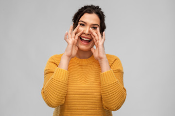 people, information and announcement concept - happy young woman with pierced nose calling over grey background