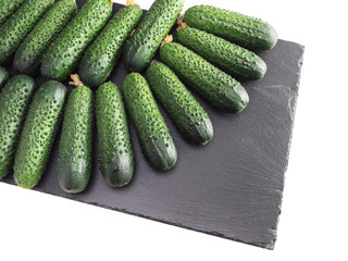 Green ripe cucumbers on black plate