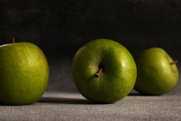 Fresh green apples on the background of the concrete mills