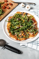 Vegan pizza with vegetables and arugula.