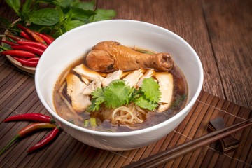 Chicken noodle soup on wood table, Chicken soup with noodles and vegetables in bowl over rustic wooden background