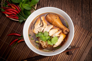 Chicken noodle soup on wood table, Chicken soup with noodles and vegetables in bowl over rustic wooden background