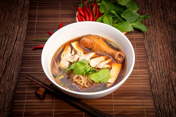 Chicken noodle soup on wood table, Chicken soup with noodles and vegetables in bowl over rustic wooden background