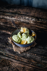 lemon, lime and mint ice cream in bowl on wooden table, refreshing seasonal dessert