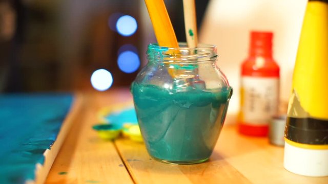 Colorimetry. Most pigments work by absorbing certain wavelengths of light. Other wavelengths are reflected or scattered, to see colours. The artist cleans brushes from blue paint in water. 