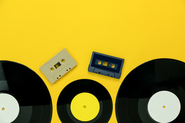 Table Top view of musical instrument retro concept.Flat lay objects of the many music disk and  cassette tape on modern rustic yellow paper at home office desk.copy space for creative design text.