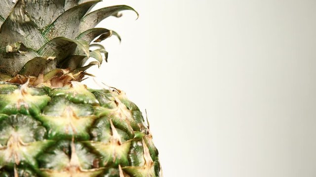Close up of fresh whole pineapple ananas fruit rotating. Healthy eating