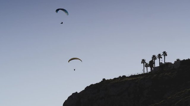 Paragliding. Extreme sport. Paraglider silhouette flying in the sky. Spain Alicante Santa Pola region.