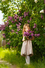 Fototapeta premium girl in a pink dress near a lilac flowers 