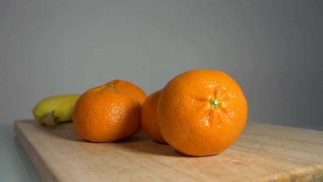 Fresh juicy mandarin oranges on breakfast table sliding shot