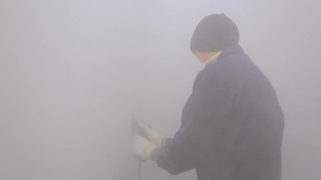 Worker removing surface cover from the wall