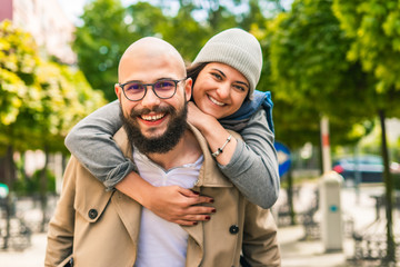 Fototapeta premium Cute young couple goofing around embracing and looking at camera