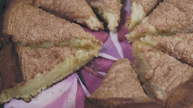 Delicious pie cut into pieces in a plate on the table closeup