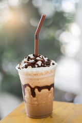 Frappe coffee placed on a wooden table in a cafe.