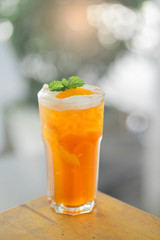Iced Peach tea on a wooden table in a cafe
