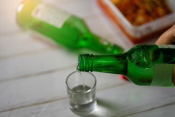 Soju bottle and small glass cup. Alcoholic Clear Distilled Korean Soju.