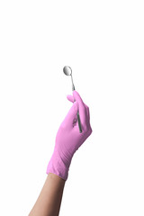 Hand in pink protective gloves holding dental mirror on white background