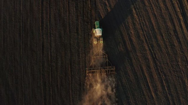 Harvester working in the field at spring and plowing the field
