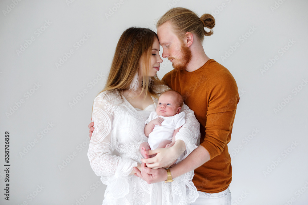 Wall mural parenthood, love and family concept - smiling mother and father holding their baby son.happy europea