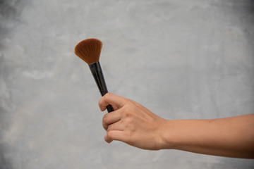Close up hand cute girl with make up brush.