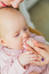Close-up. Beautiful young mother holds the hands of her little daughter. Baby. Newborn.