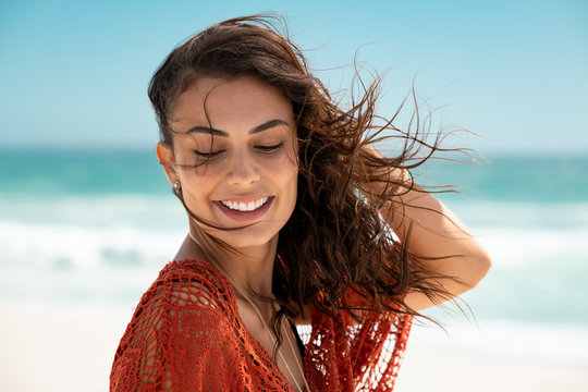 Beautiful latin woman enjoying wind at beach