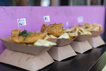 Naklejka na ściany i meble Street Food: Fried Fish and Chips Served in a Small Paperboard