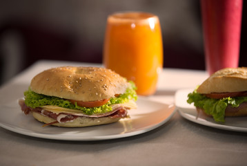 closeup of Ham and cheese sandwiches with orange and raspberry juice. Food photography.