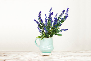 Lavender flowers in a mug on a marble table