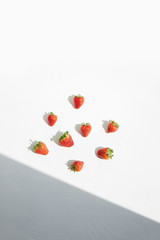 
Ripe red strawberries and shadow angle on a white surface.